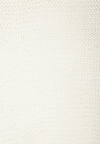 Kremowa dzianina o fakturze z jednolitym wzorem, z małymi wypukłymi oczkami tworzącymi miękką, przewiewną powierzchnię.