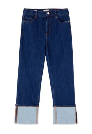 Siniset farkut leveillä käänteillä, jotka paljastavat vaaleamman sisäpuolen kankaan ja sivuvetoketjut käänteissä, etutaskuissa ja napinauhassa.