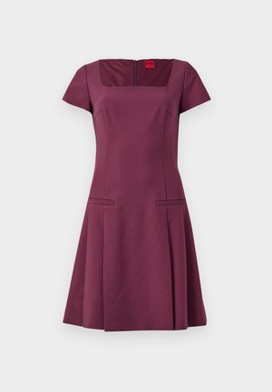 Bordeauxfarbenes Kleid mit quadratischem Ausschnitt, kurzen Ärmeln und seitlichen Taschen. Hergestellt aus strukturiertem Stoff, mit einem verdeckten Reißverschluss auf der Rückseite.