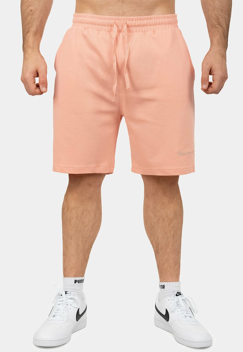 Shorts di cotone color pesca con vita elastica e cordoncino; dotati di tasche laterali e un piccolo logo ricamato sull'orlo.