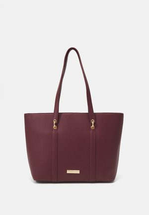 Burgundy tote bag with a textured finish, two long handles, and gold-tone hardware accents. Features a prominent brand name plate at the front.