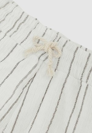 Weiße Stoffhose mit vertikalen schwarzen Streifen und einer gedrehten Kordel als Tunnelzug, die an der Taille zu einer Schleife gebunden ist.