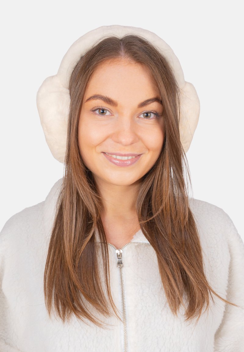 Cache-oreilles en fausse fourrure blanche avec un design arrondi, présentant une texture douce et une doublure moelleuse ; portés sur des cheveux longs et raides.