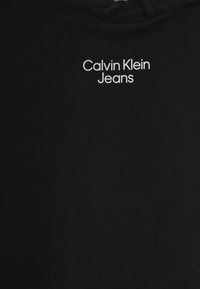 Felpa nera con tessuto testurizzato, con il logo bianco "Calvin Klein Jeans" centrato sul petto.