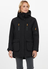 Sort parka-jakke med høj krave, lynlåslomme på brystet og sidelommer samt justerbar hætte. Har toggles og en mat finish.
