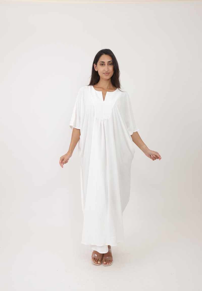 Kaftan blanc ample avec un col en V, des manches courtes et des détails froncés à l'avant. Tissu léger et lisse avec une coupe fluide.