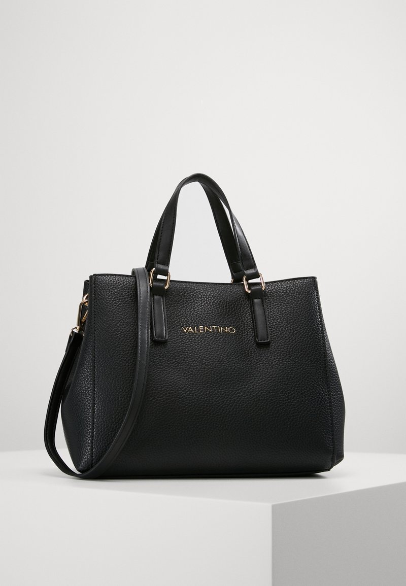 Black leather handbag with pebbled texture, two top handles, and a removable shoulder strap. Features gold logo on the front.