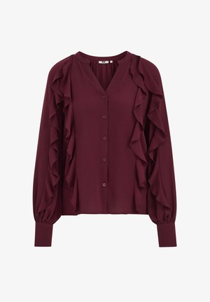 Blouse bordeaux avec des détails à volants le long du devant et des manches, dotée d'une fermeture à boutons et de poignets longs et ajustés. Texture du tissu lisse.