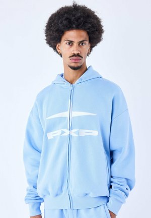 Sudadera con cremallera de color azul claro, fabricada en un tejido suave, que presenta un gran logo blanco de PXP en la parte frontal, con capucha ajustable y mangas con puños.