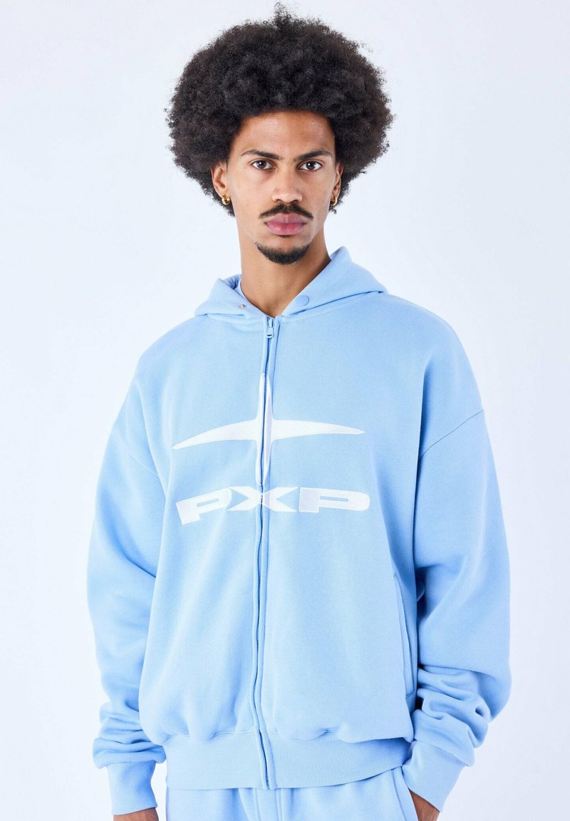 Sudadera con cremallera de color azul claro, fabricada en un tejido suave, que presenta un gran logo blanco de PXP en la parte frontal, con capucha ajustable y mangas con puños.
