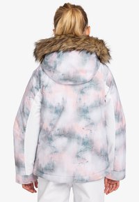 Veste d'hiver colorée en tissu doux, présentant un motif de forêt aquarelle en rose et bleu, avec une capuche doublée en fausse fourrure et des accents blancs.