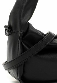 Schwarze Lederhandtasche mit rundem Griff, genähtem Riemen und Metallring-Detail auf weißem Hintergrund.