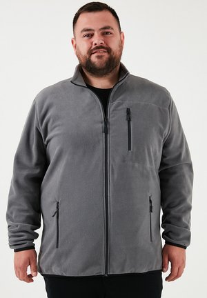 Grau Fleece-Jacke mit hohem Kragen, Reißverschluss vorne und zwei Seitentaschen. Mit strukturiertem Stoff und schwarzen Reißverschlussakzenten.