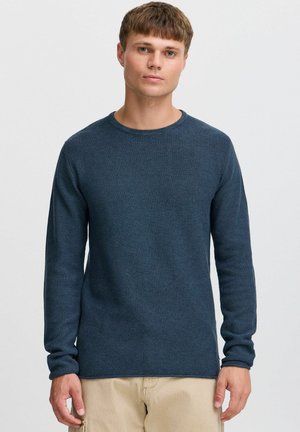 Suéter de punto azul marino con mangas largas y cuello redondo. Presenta un patrón texturizado y puños y dobladillo acanalados.