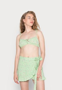 Biquíni floral verde menta com alças ajustáveis e uma saia envolvente combinando, com bainha em camada e detalhe de laço.