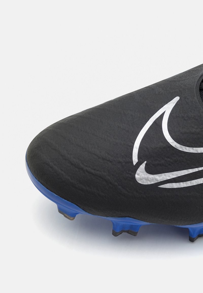 Botín de fútbol negro con un upper texturizado, suela azul y un prominente logo blanco de Nike. Presenta una forma aerodinámica para mejorar el rendimiento.