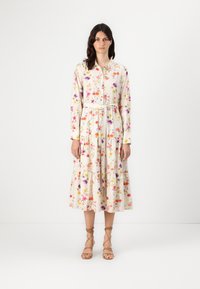 Rochie midi florală în crem, cu mâneci lungi, croială dreaptă, închidere cu nasturi în față, talie strânsă și fustă cu volane, decorată cu flori multicolore.