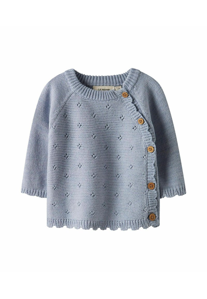 Gaiši zilā adīta džemperis ar īsām piedurknēm, vilnis formas apakšmala un koka pogas gar sānu; visa virsma ar fakturētām detaļām.