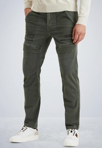 Olivgrüne Cargo-Hosen mit mehreren Taschen, geradem Bein Design, Reißverschluss und leichtem Stoff. Kombiniert mit weißen Sneakers.