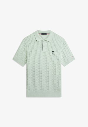 Hellgrünes Polohemd mit kurzen Ärmeln und Zopfmuster, Zwei-Knopf-Leiste, besticktem Tommy Hilfiger-Logo auf der Brust und kleinem Flaggen-Detail am Ärmel.