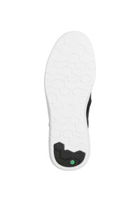 Black and white sneaker sole with a hexagonal pattern, featuring a green accent and textured grip for traction.