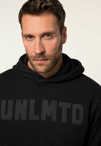 Sort hættepullover lavet af blødt stof med et stort, iøjnefaldende "UNLMNTD" grafik på brystet. Justerbar snorhætte inkluderet.