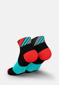 Bunt gemusterte Knöchelsocken mit schwarzem Körper, leuchtend roten Zehen und Fersen sowie türkisfarbenen Akzenten und einem gestreiften Muster an der Spitze.