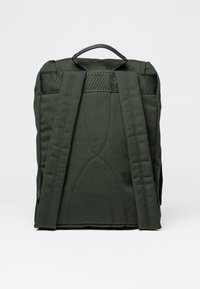 Zaino in tessuto verde scuro con design imbottito, spallacci spessi e maniglia superiore; presenta un motivo trapuntato sul retro.