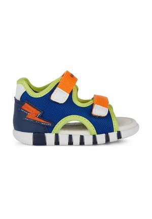 Sandaal abierto de color azul y verde con tiras de Velcro en naranja y blanco, parte superior de malla texturizada y una suela blanca acolchada con diseño de rayas.