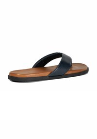 Navy leather flip-flop with a wide strap, tan cushioned sole, and black rubber outsole. Simple design and flat profile for comfort.