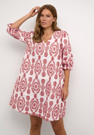 Vestido blanco con patrones florales y geométricos rojos, con escote en V y mangas tres cuartos fruncidas. Tejido suave y corte relajado.