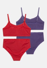 Zwei Sets lässiger Unterwäsche, eines in Rot und eines in Lila, mit weichem Stoff, verstellbaren Trägern und glatter Textur.