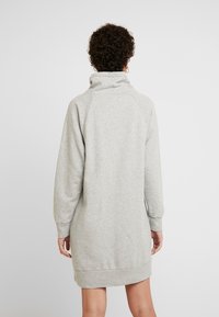 Abito felpa grigio chiaro con colletto alto, maniche lunghe a raglan, polsini a coste e orlo dritto, realizzato in morbido tessuto felpato.