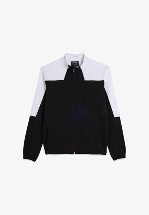 Chaqueta negra y blanca con cremallera y cuello alto, que cuenta con un bolsillo en el pecho, bolsillos laterales y puños acanalados. Fabricada con tela suave.