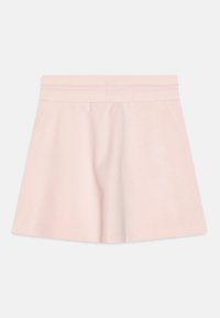 Jasnoróżowa spódnica z elastycznym pasem, wykonana z miękkiego materiału. Rozkloszowany krój z gładką fakturą, bez dodatkowych wzorów czy ozdób.
