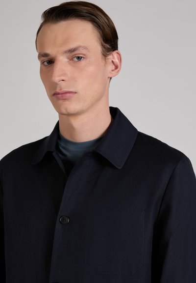 Marineblaue Jacke mit Knopfverschluss, großem Kragen und Fronttasche. Hergestellt aus strukturiertem Stoff, der eine strukturierte Passform und ein elegantes Erscheinungsbild bietet.