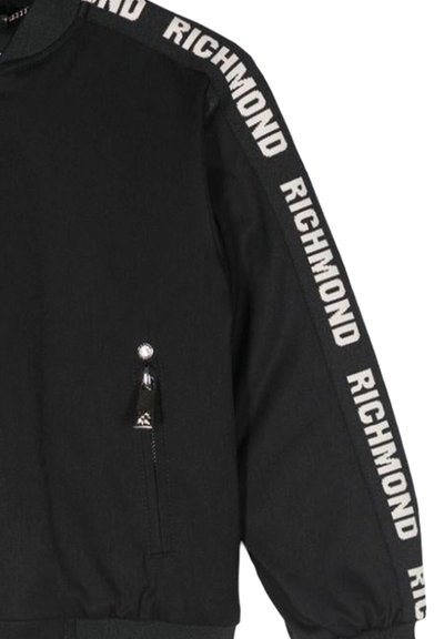 Giacca bomber nera con colletto alto, caratterizzata da branding bianco "RICHMOND" sulle maniche e una tasca laterale con zip. Tessuto dalla superficie liscia.