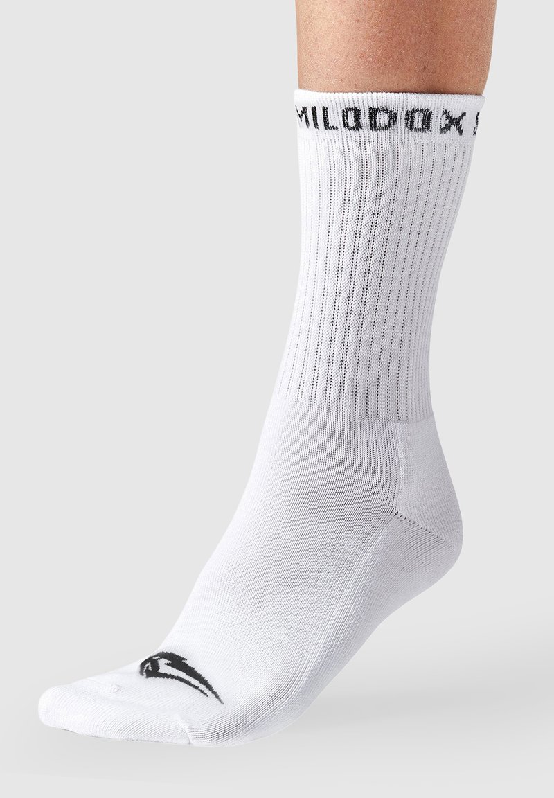 Calcetín deportivo blanco con textura acanalada que presenta un logo negro en la puntera y texto negro en el puño. El material tiene un aspecto suave y elástico.