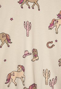 Beiger Stoff mit bunten, bedruckten Motiven, darunter Pferde, Kakteen, ein Cowboyhut, Stiefel und Sterne, mit rosa und braunen Akzenten.