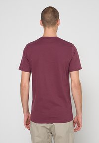 T-shirt met korte mouwen in donker bordeaux katoen, met een ronde halslijn en een eenvoudig, strak ontwerp zonder versieringen of patronen.