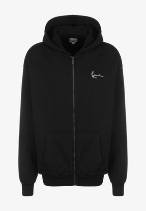 Zwarte zip-up hoodie gemaakt van een zacht materiaal, met een voorzak, ribgebreide mouwen en een klein wit logo op de linkerborst.