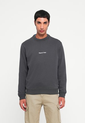 Felpa grigia in cotone con colletto e polsini a costine, con testo ricamato bianco sul petto, abbinata a pantaloni cargo beige chiaro.