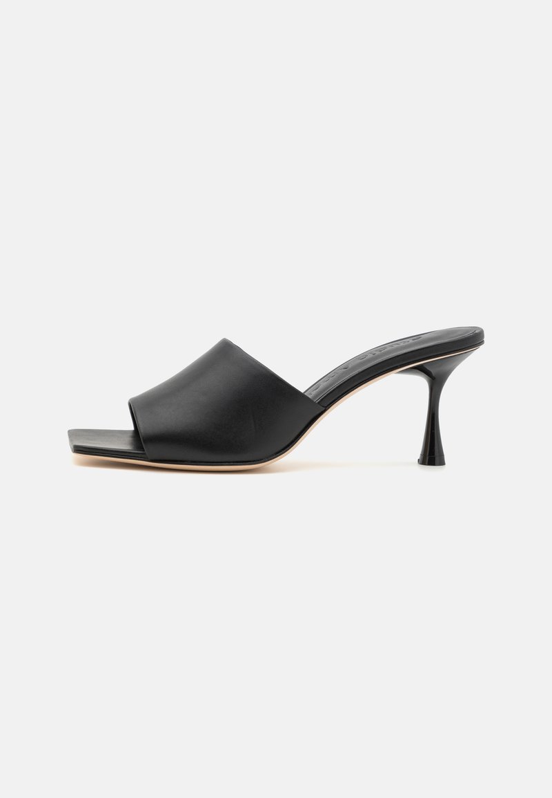 Black leather mules with a square open toe and a tapered high heel. Features a smooth texture and minimalist design.