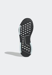 Svart gummisula till skon med ett geometriskt bikakemönster, med ljusblå accenter och en texturerad kant för grepp och hållbarhet.