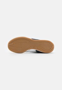 La suola delle sneaker presenta un materiale in gomma naturale con un motivo testurizzato per garantire aderenza. Design semplice nei colori neutri, senza marchi visibili.