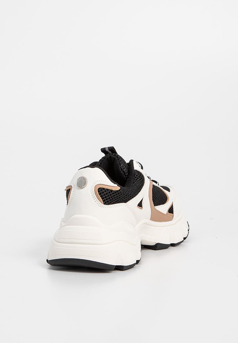 Klobiger Sneaker mit einem weißen Obermaterial, schwarzen Mesh-Akzenten und beigen Details. Verfügt über eine dicke weiße Sohle und eine Schlaufe an der Rückseite.