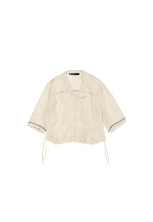 Off-white blouse met een kraag, driekwartmouwen, knoopsluiting en een gestructureerde stof. Bevat zwarte accenten op de manchetten.