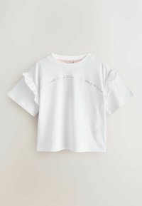 Camiseta blanca de manga corta con detalles fruncidos, con texto delicado impreso en el pecho en una fuente sutil. Material suave de algodón.