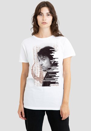 White cotton t-shirt featuring a graphic design of a face in shades of black and brown, with vertical lines and the word "ANDOR" at the bottom.