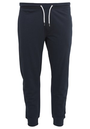 Navyblå joggebukser laget av myk bomullsblanding, med elastisk midje og hvite snorer, samt smalere ermer ved anklene.